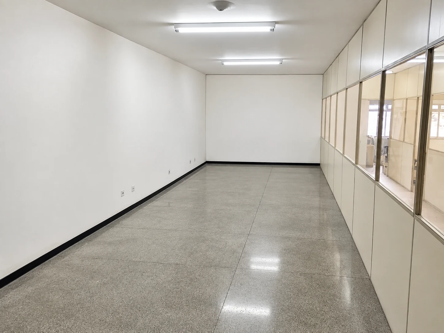 Sala comercial ampla, com piso e divisórias envidraçadas